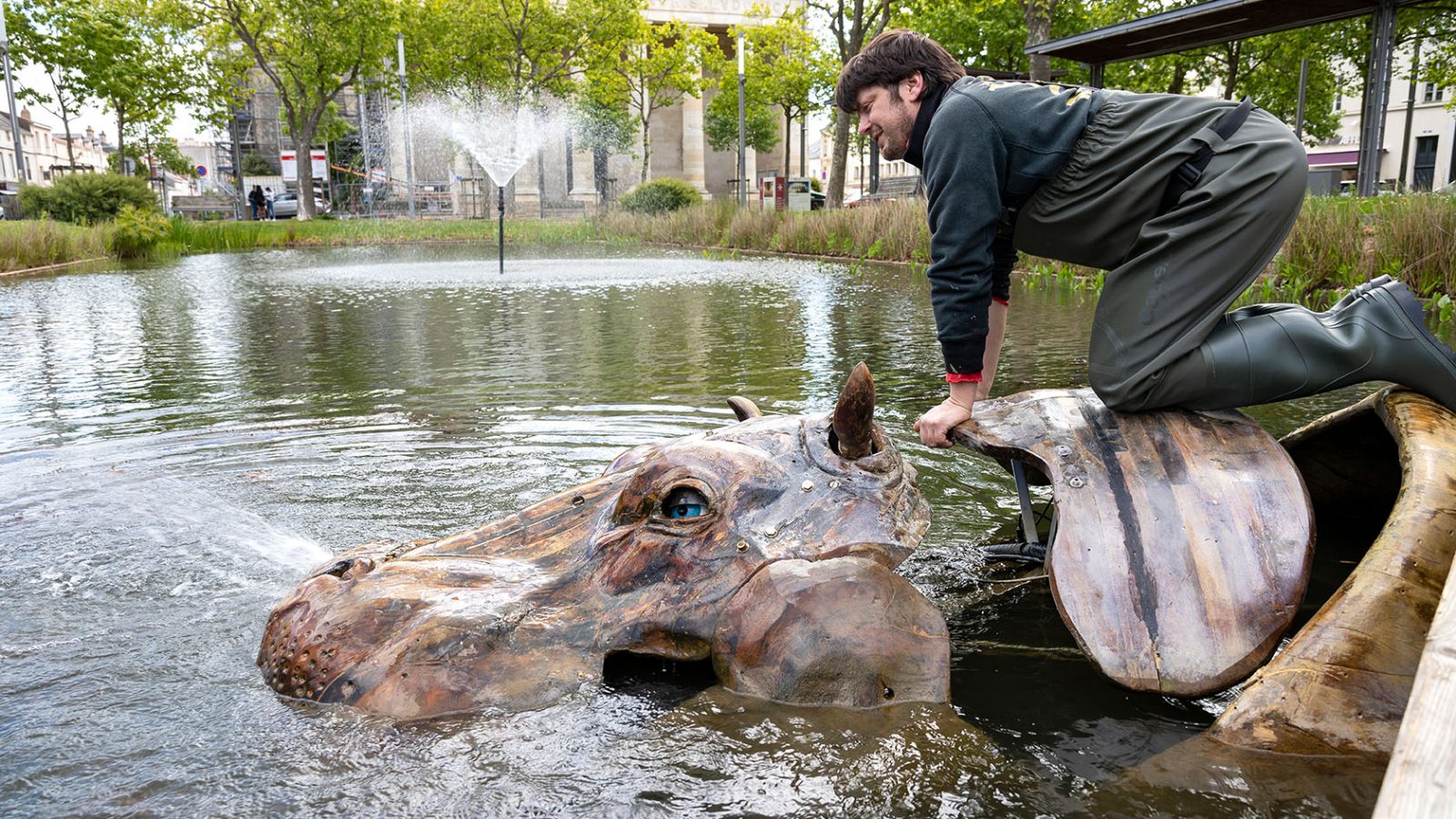 Un technicien monté sur le dos de l'hippopotame mécanique des Animaux de la Place Napoléon à La Roche-sur-Yon